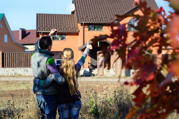 Young Couple Standing Outside Dream Home