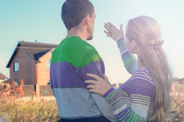 Young Couple Standing Outside Dream Home