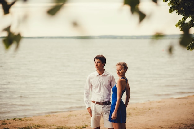 Young couple standing on the shore of the lake