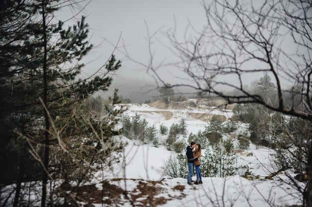 Coppia giovane in piedi su un campo invernale innevato n