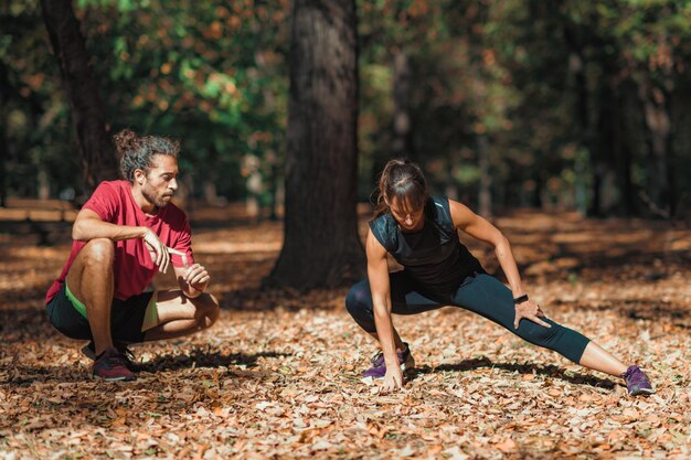 Foto giovane coppia che si allunga dopo l'allenamento nel parco