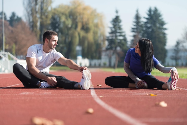 Young Couple Stretching Before Running In City Park Area  Training And Exercising For Trail Run Marathon Endurance  Fitness Healthy Lifestyle Concept Outdoor