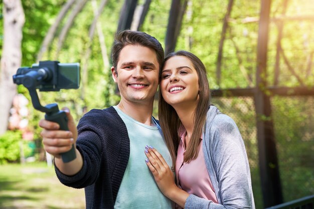 young couple strolling in the park and taking pictures