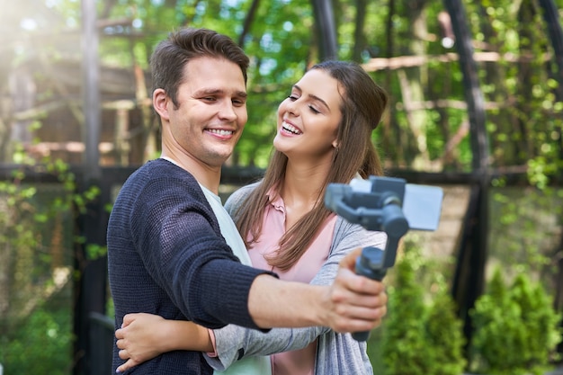 young couple strolling in the park and taking pictures