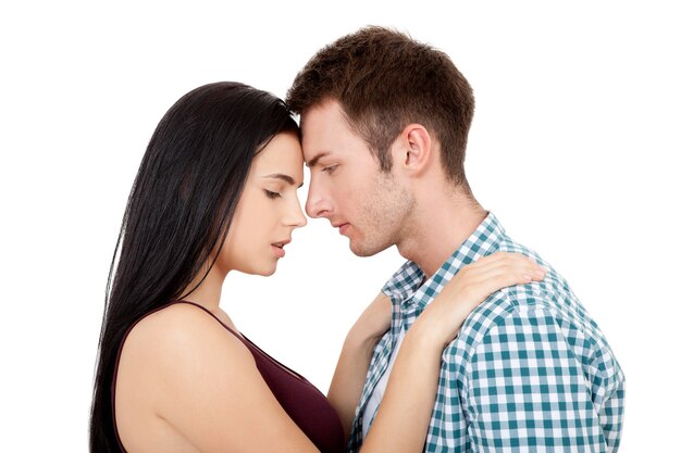 Young couple in summer clothes look at each other hugging