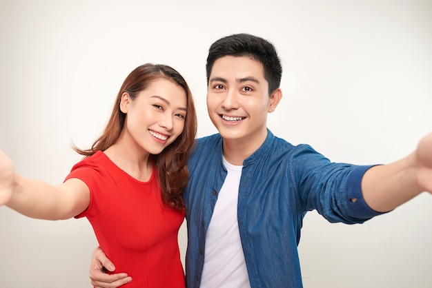 Young couple take selfie on white background