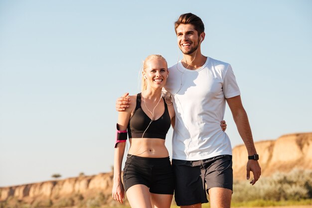 Young couple taking a break from exercises outdoors