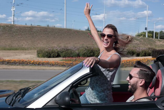 Young couple taking selfie in convertible car