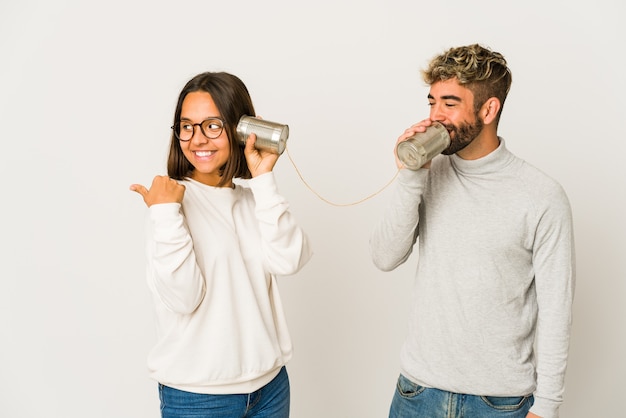 Young couple talking through a tin cans