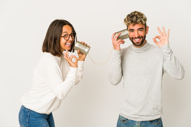 Young couple talking through a tin cans