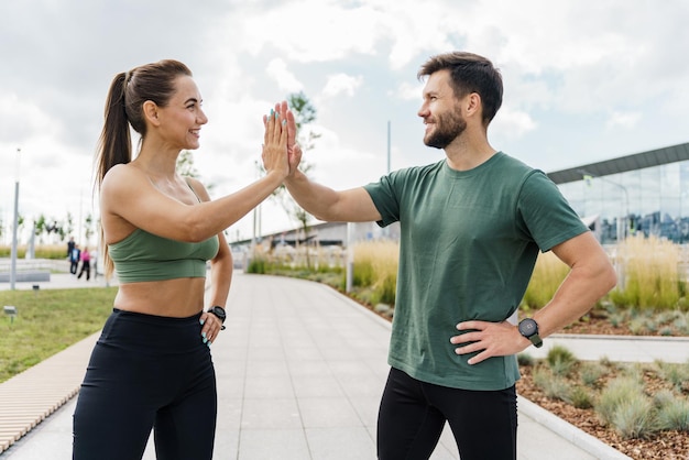 A young couple team exercises in full growth Enjoy the fitness watch and the app Male and female