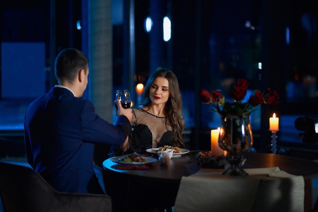 Photo young couple toasting with red wine during date at home