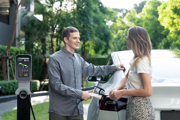 Young couple travel with EV electric car in green sustainable city innards