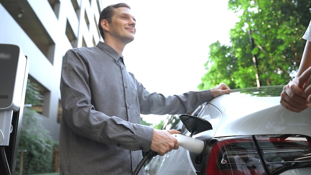 Young couple travel with ev electric car in green sustainable city innards