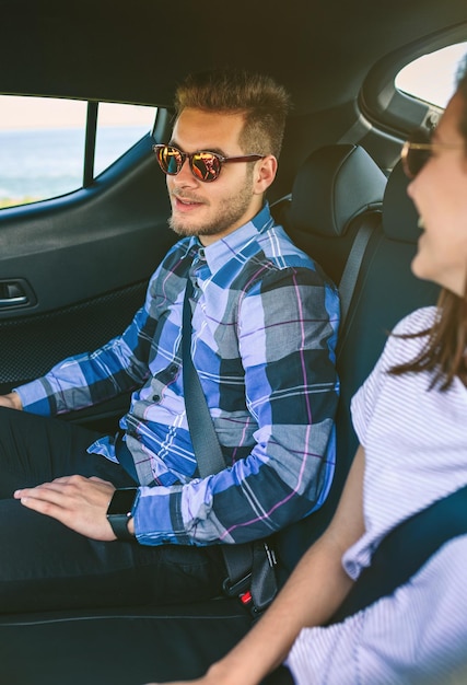 Young couple traveling by car with seat belts on