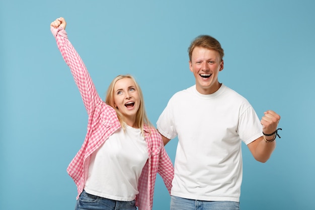 Young couple two friends guy girl in white pink empty blank design t-shirts posing 