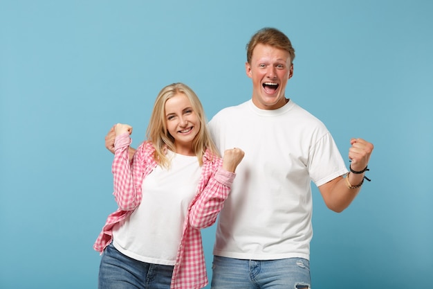 Young couple two friends guy girl in white pink empty blank design t-shirts posing 