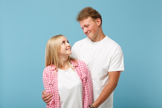 Young couple two friends guy girl in white pink empty blank design t-shirts posing 