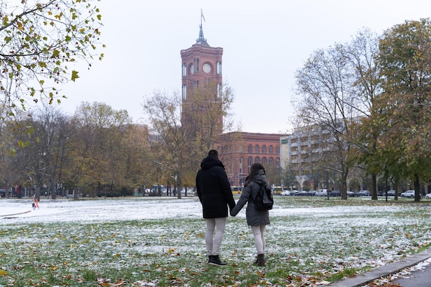 Young couple unrecognizable from behind in the park in front of the Rotes Rathaus in Berlin with all the snow in the snow