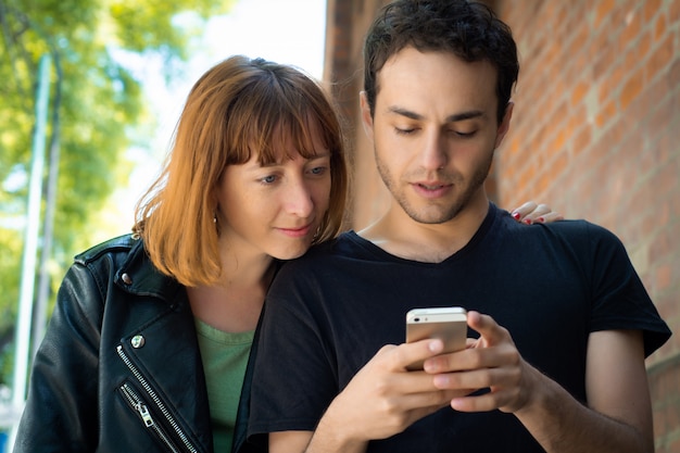 Young couple using application on smartphone