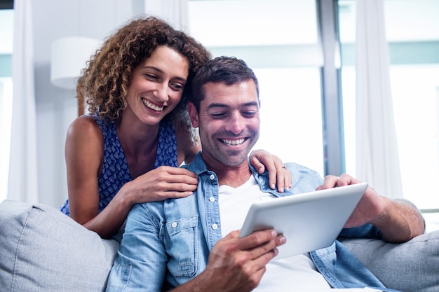 Молодая пара с помощью цифрового планшета на диване