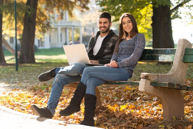 Young Couple Using Laptop At Outdoor In Park