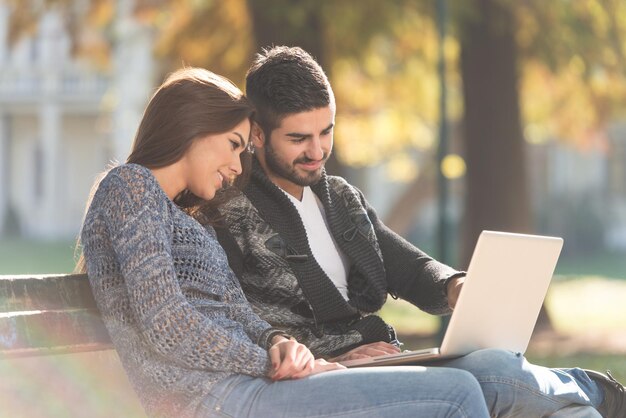 Young Couple Using Laptop At Outdoor In Park