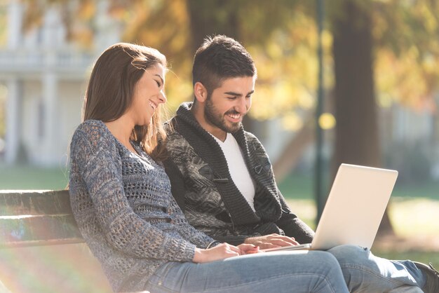 Young Couple Using Laptop At Outdoor In Park