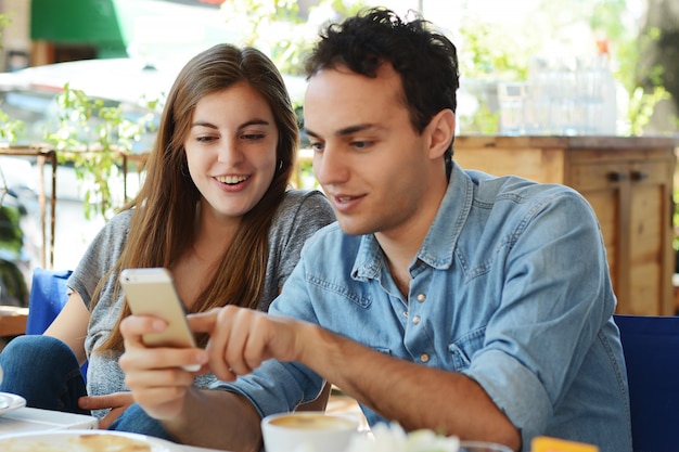 Young couple using smartphone.