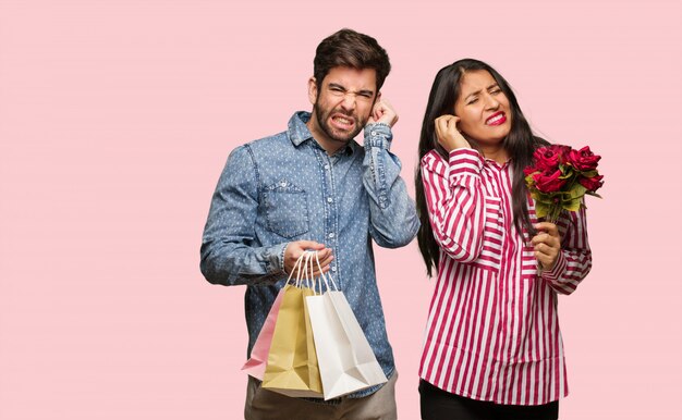 Young couple in valentines day covering ears with hands