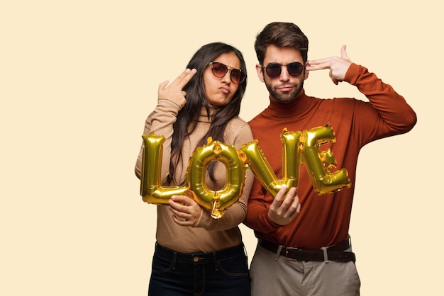 Young couple in valentines day doing a suicide gesture