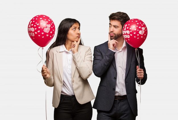 Young couple in valentines day doubting and confused