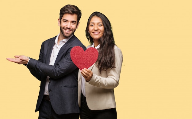 Young couple in valentines day holding something with hand