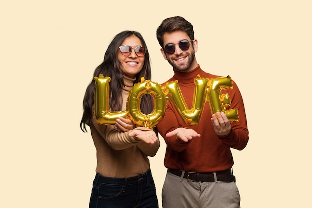 Young couple in valentines day holding something with hands