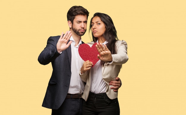 Young couple in valentines day putting hand in front