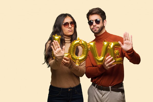 Young couple in valentines day putting hand in front