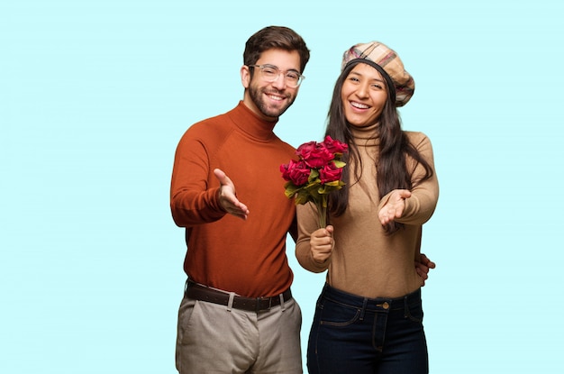 Young couple in valentines day reaching out to greet someone