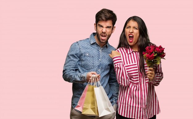 Young couple in valentines day screaming very angry and aggressive