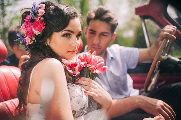 Young couple in vintage cars