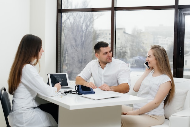 A young couple waiting for a baby to consult a gynecologist after an ultrasound. Pregnancy, and health care