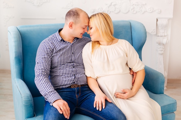 Young couple waiting for a small child sitting on a sofa