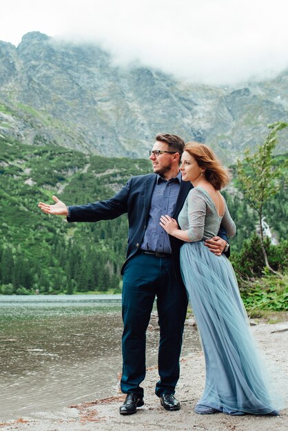 Young couple on a walk near the lake surrounded by the Carpathian mountains