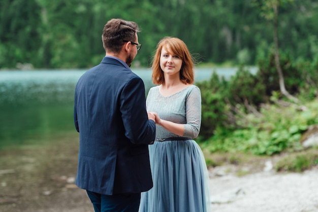 Young couple on a walk near the lake surrounded by the Carpathian mountains