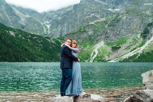 Young couple on a walk near the lake surrounded by the Carpathian mountains