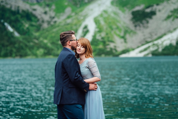 Young couple on a walk near the lake surrounded by the Carpathian mountains