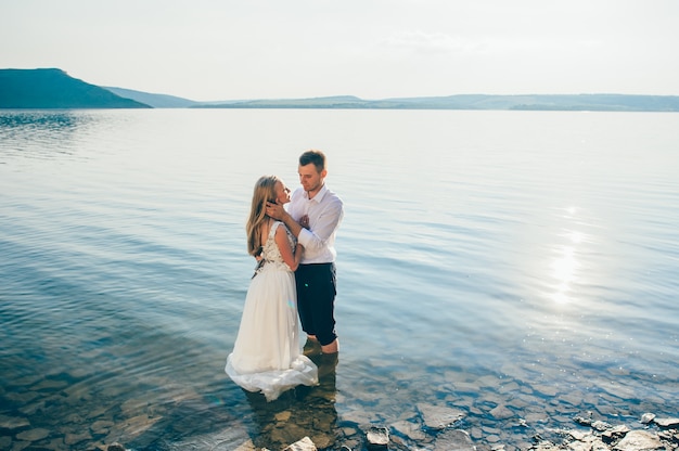 Young couple walk on sandy beach