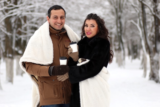 A young couple walk in a winter park outdoor