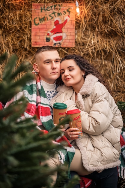 Young couple walking in the christmas garden near the christmas tree