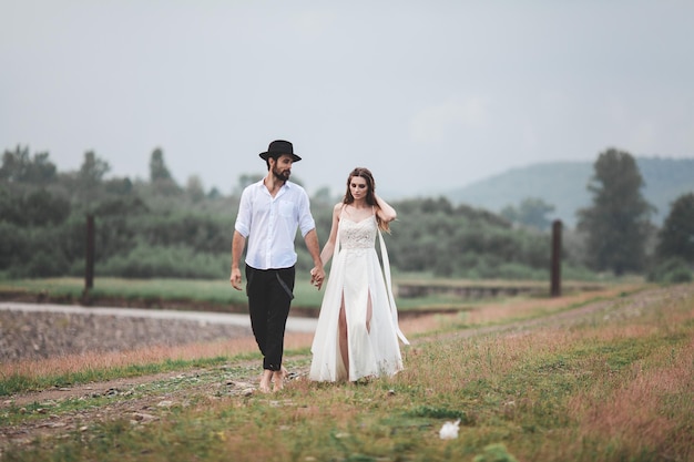 Photo young couple walking on field against sky