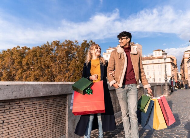 Young couple walking in town with shopping bags shopping time autumn and winter season